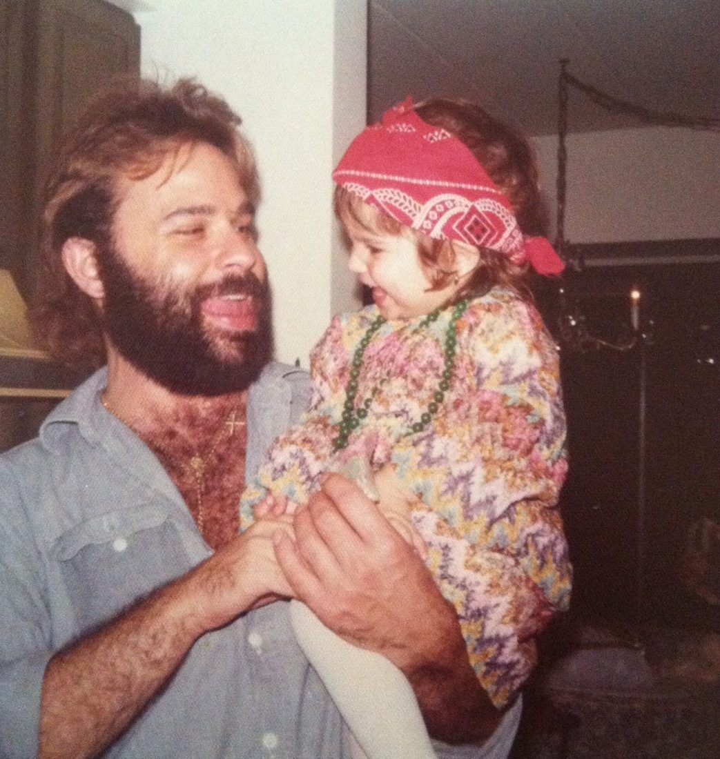 Lou Christie holding his daughter, dressed as a little gypsy for Halloween